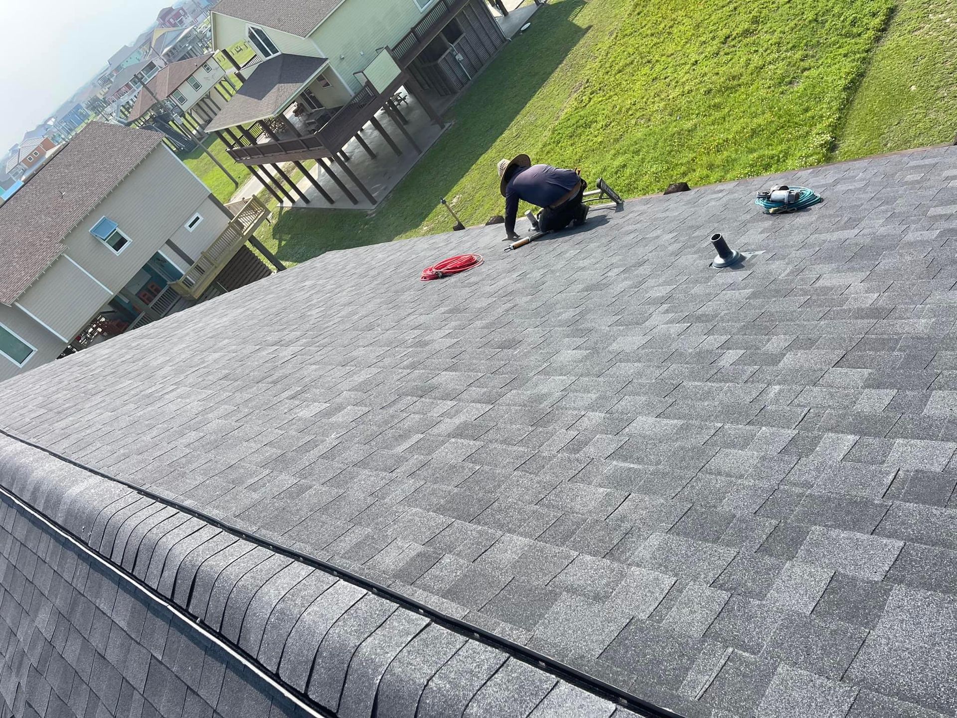 A man is working on the roof of a house.