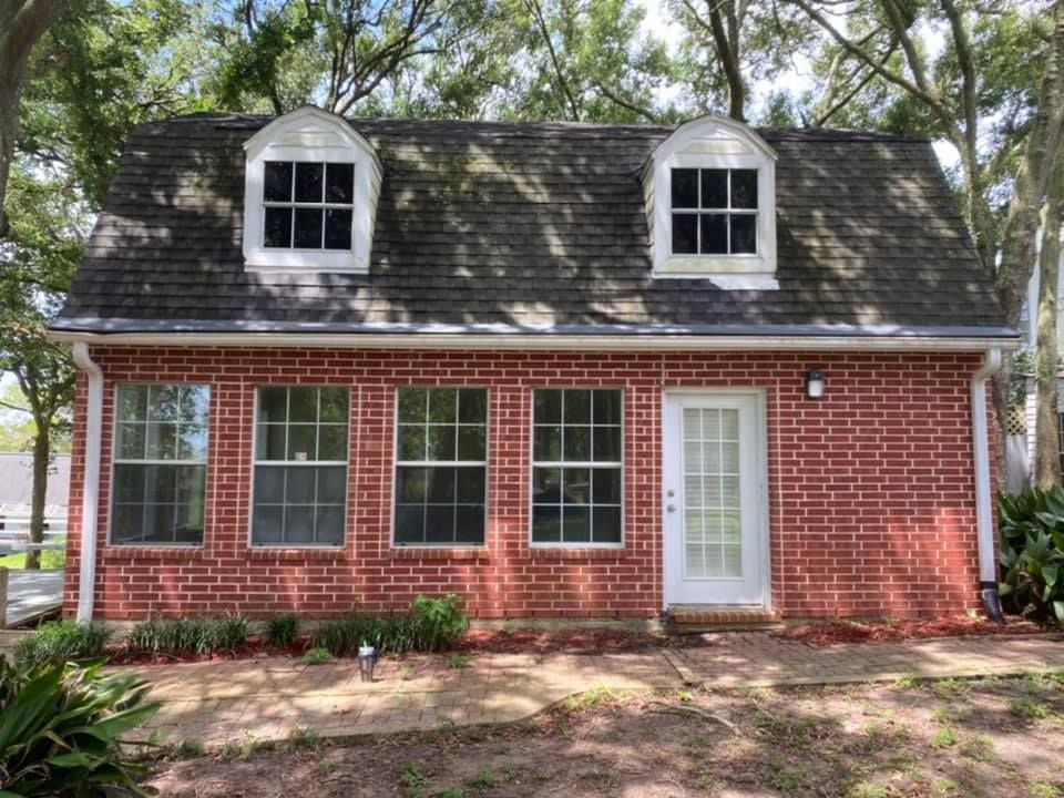 A red brick house with a white door and windows