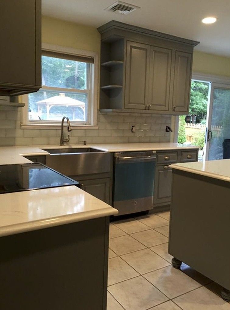 Modern kitchen with gray cabinets, tile floor, stainless appliances, and a window over the sink