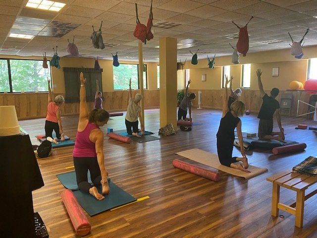 A group of people are doing yoga in a gym