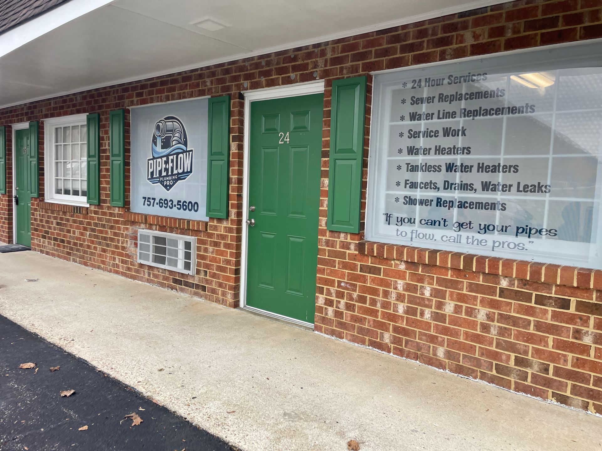 Brick building with green door and shutters; Ice Age business sign. Services are listed on the window.