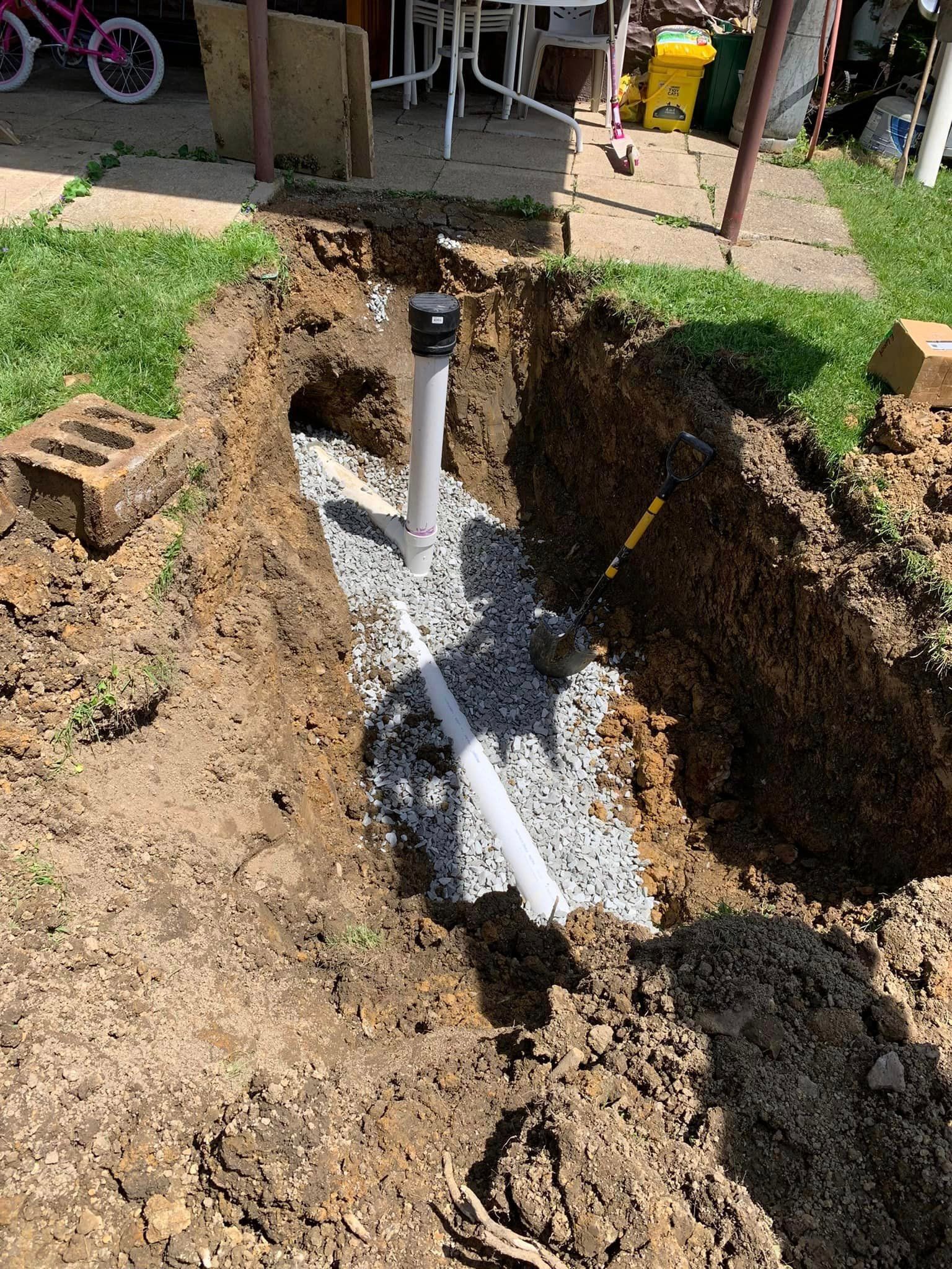 A pipe is being installed in a hole in the ground.