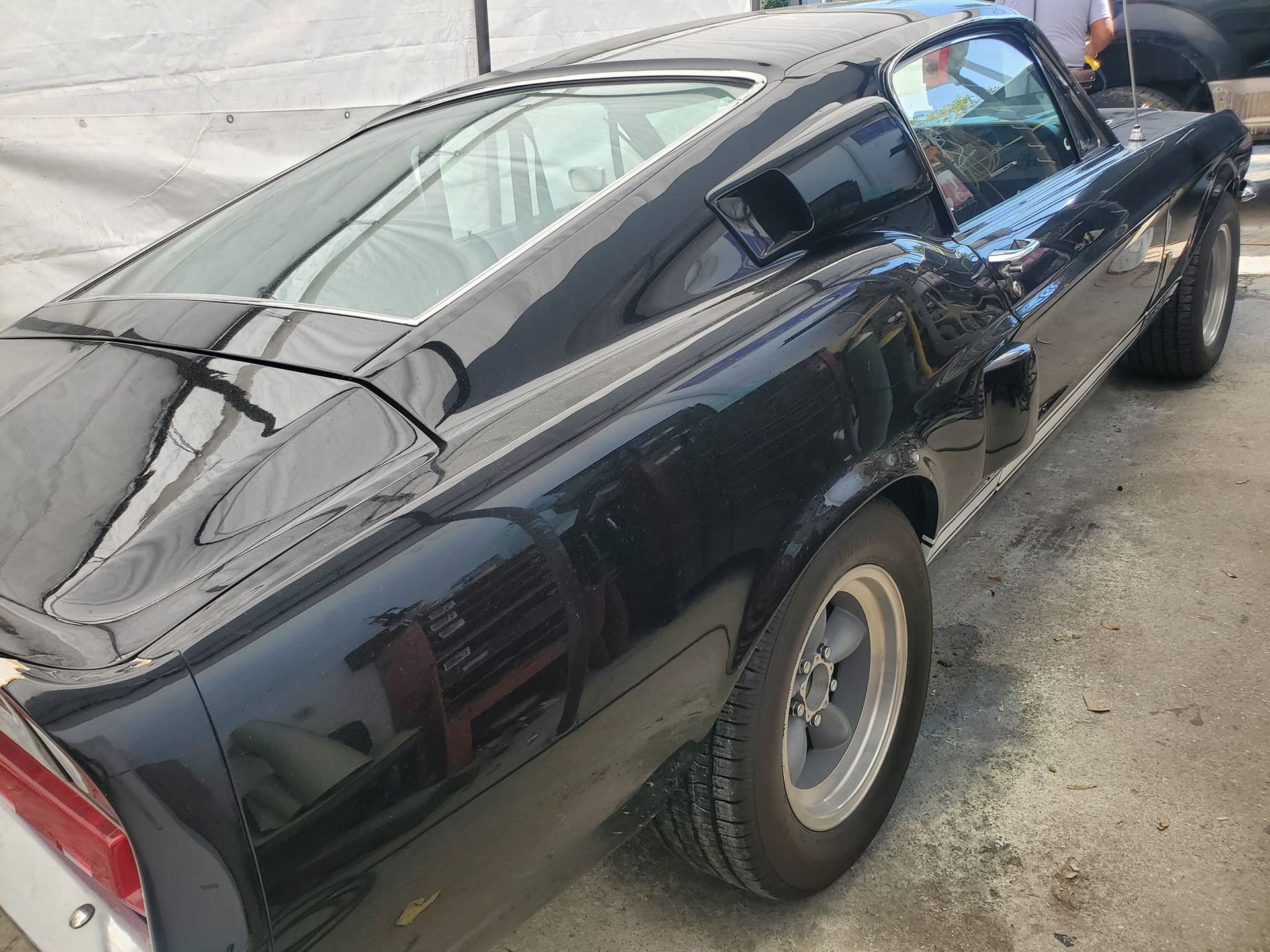 A black mustang is parked on the side of the road