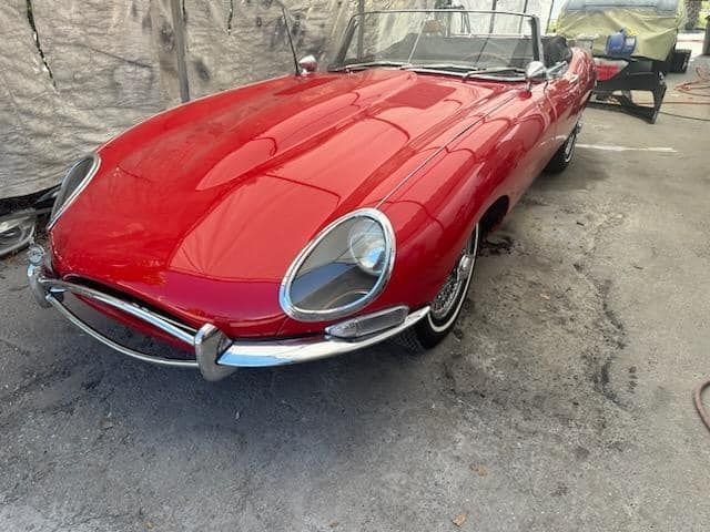 A red sports car is parked in a parking lot