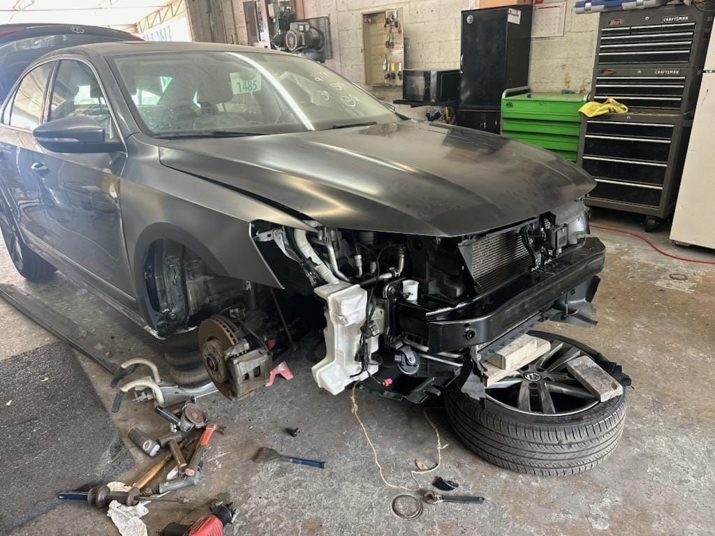 A volkswagen jetta is being repaired in a garage.