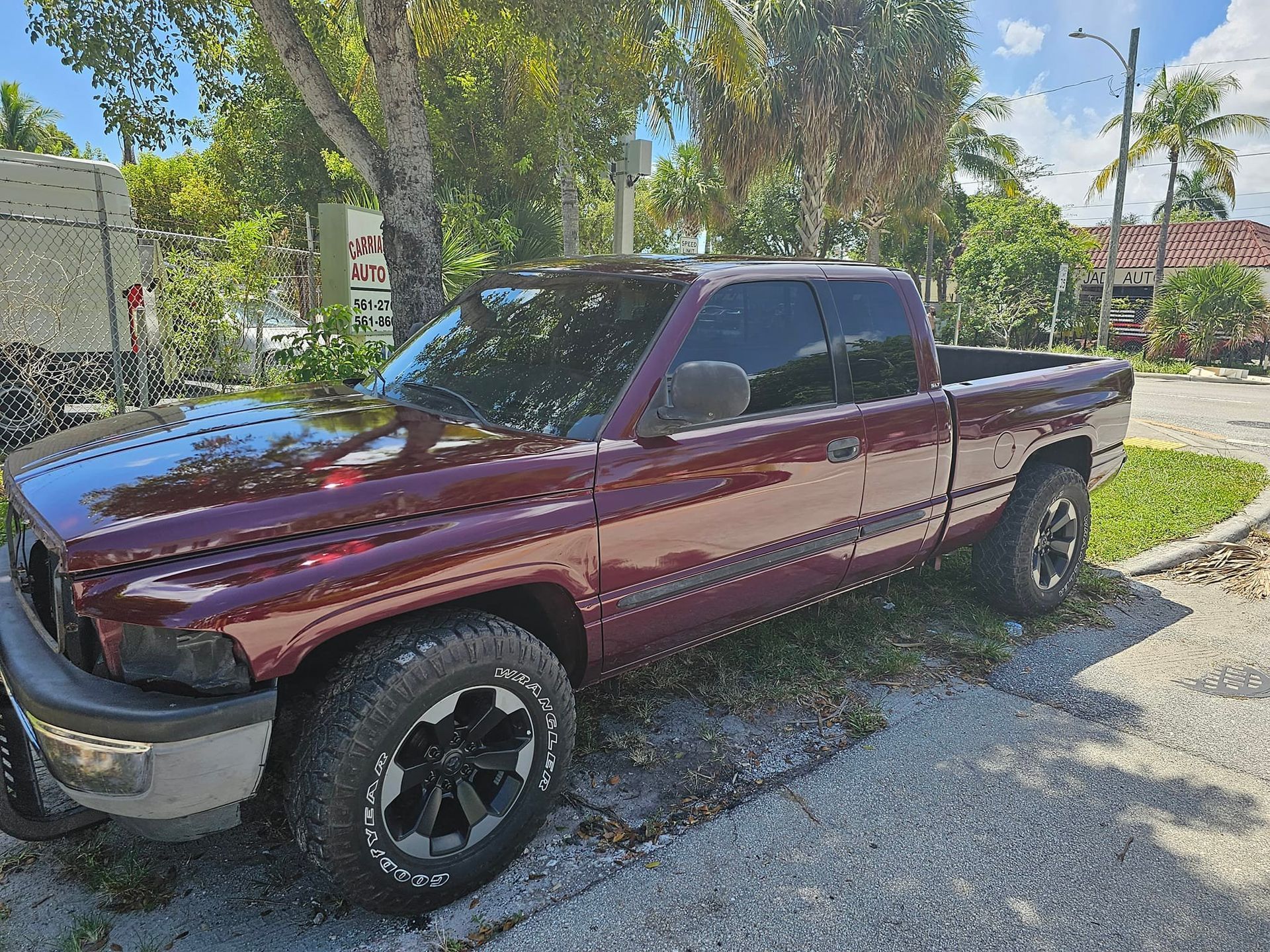 A red dodge ram truck is parked in a gravel lot.