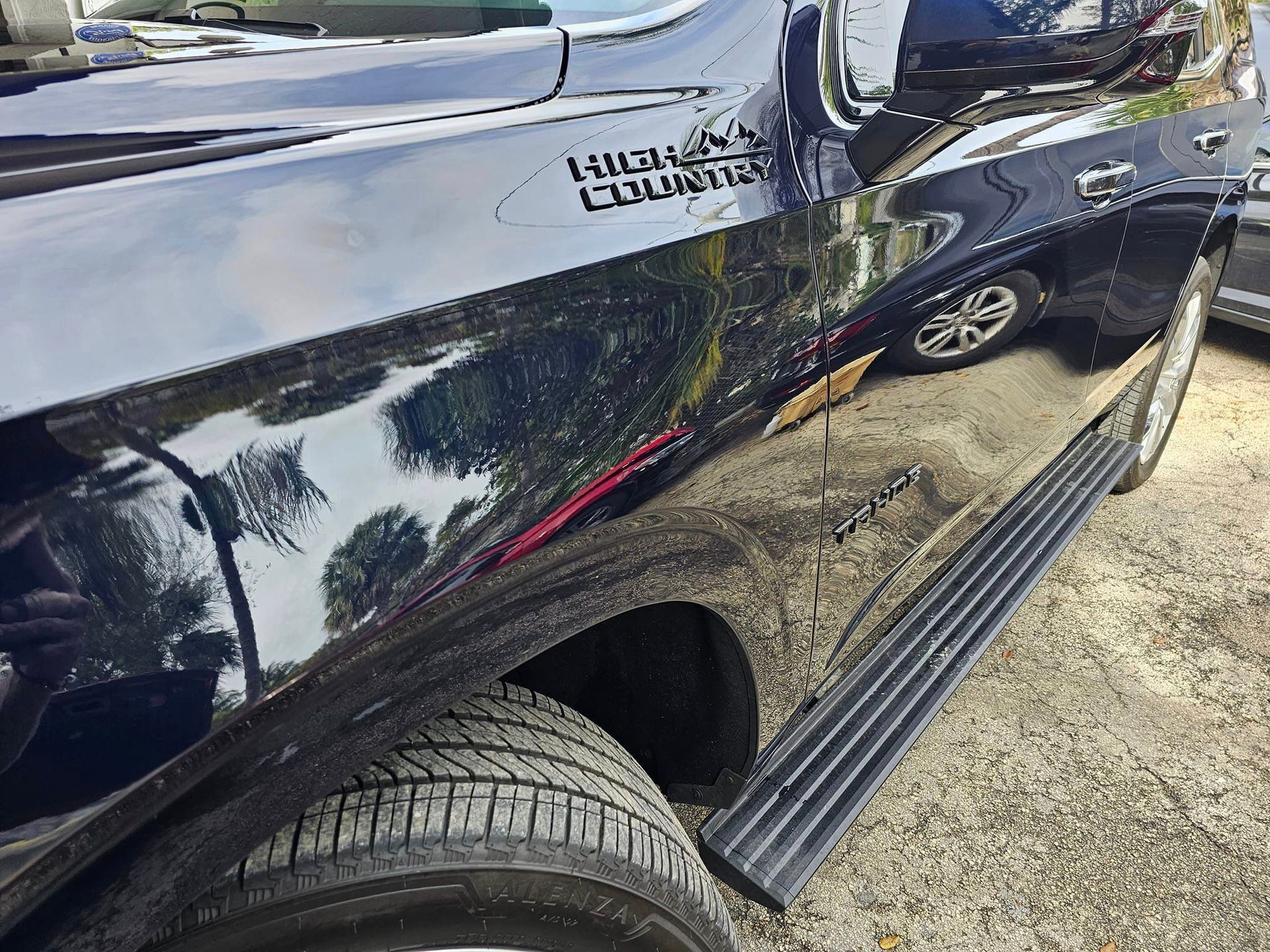 A black truck is parked on the side of the road.