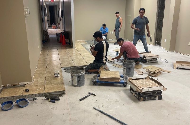 A group of men are working on the floor of a building.