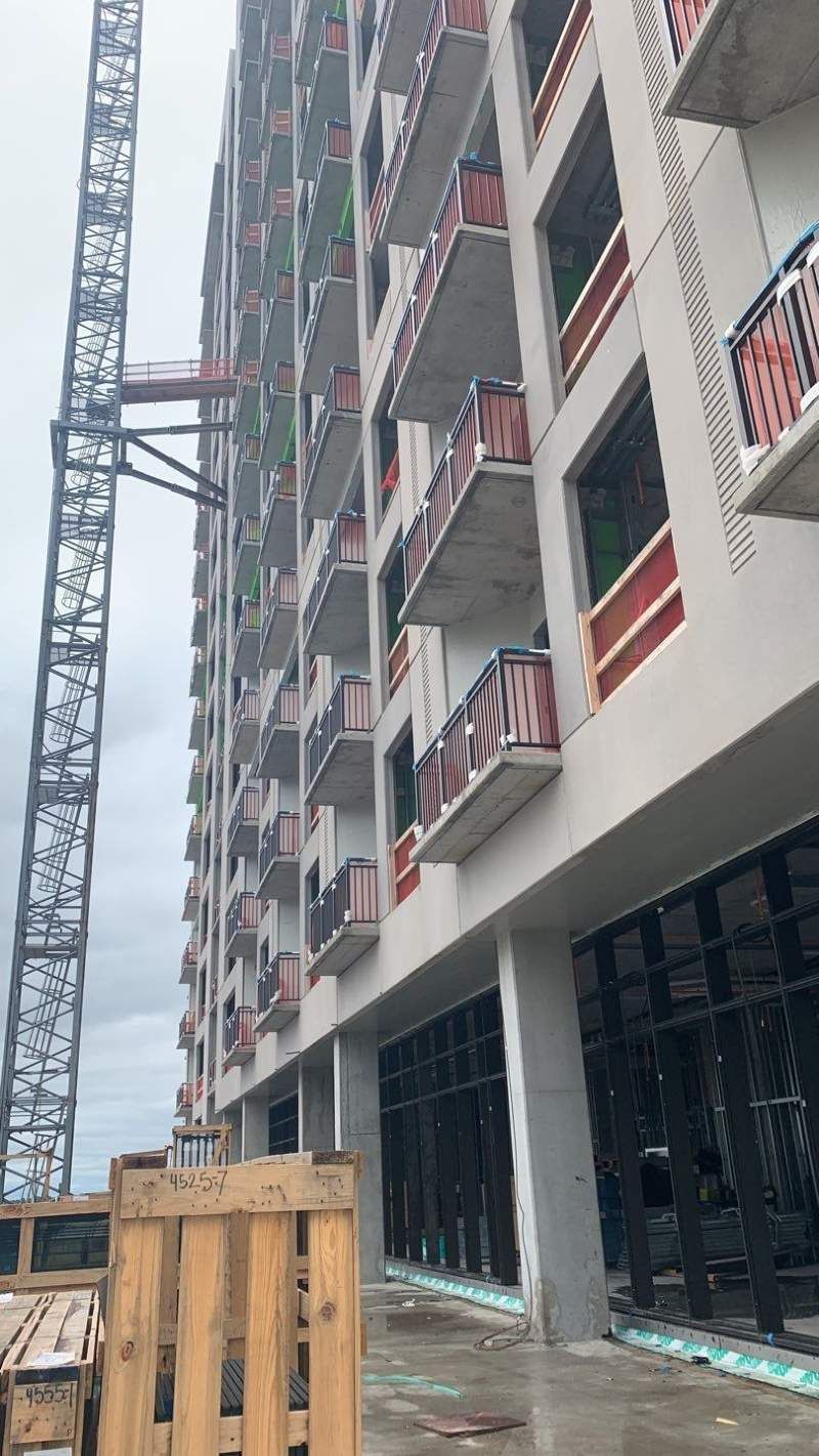 A large building under construction with a crane in front of it.