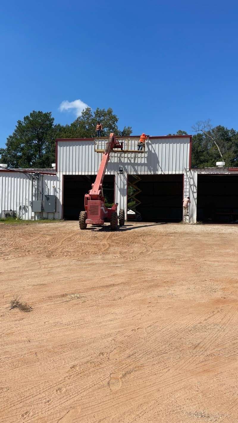 A man is working on the roof of a building with a crane.