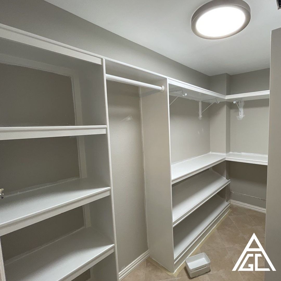 A walk in closet with shelves and a light on the ceiling