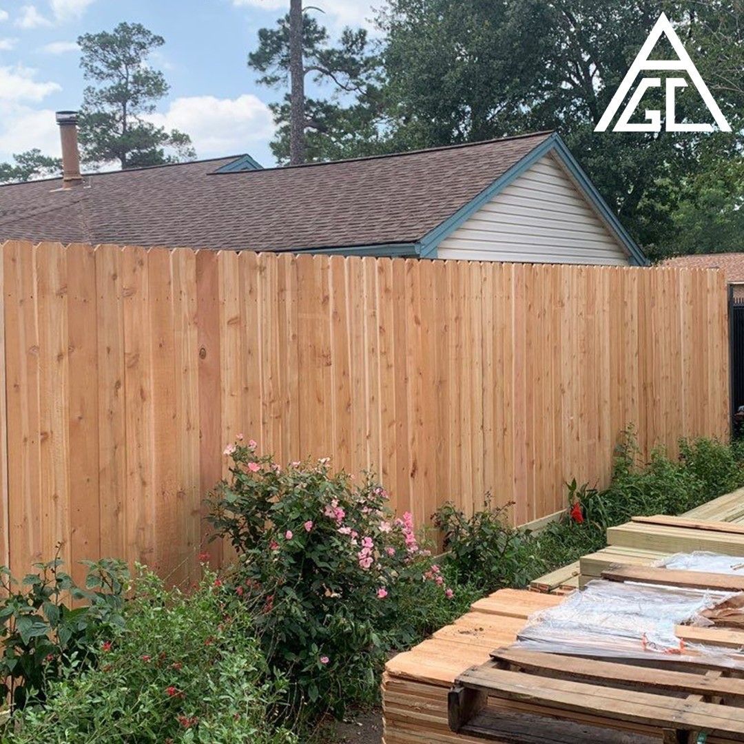 A wooden fence is being built in front of a house.