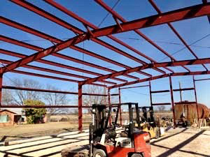 A forklift is parked inside of a building under construction.