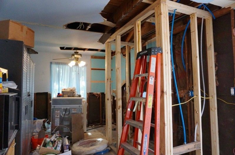 A ladder is sitting in the middle of a room under construction.