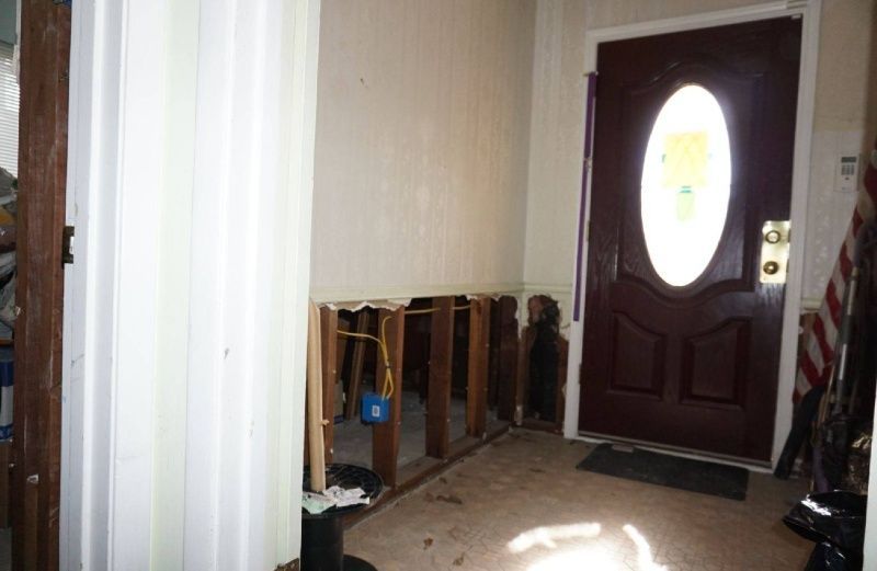 A hallway with a red door and a window.