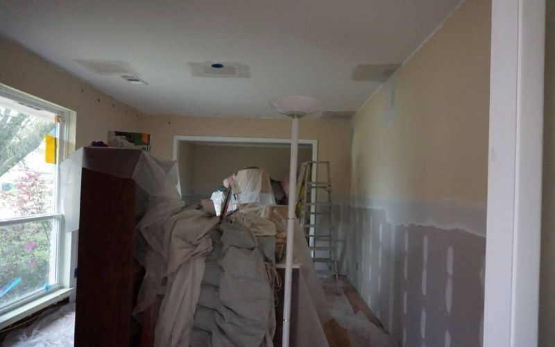 A room that is being painted with a ladder in it.