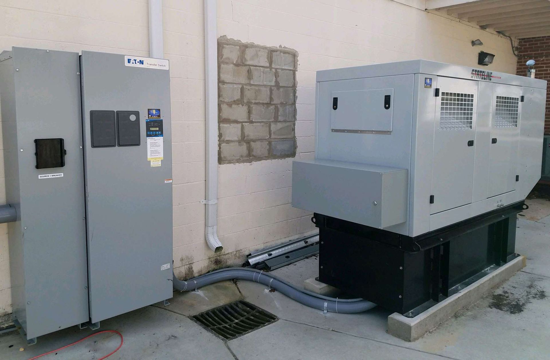 A couple of generators are sitting on the side of a building.