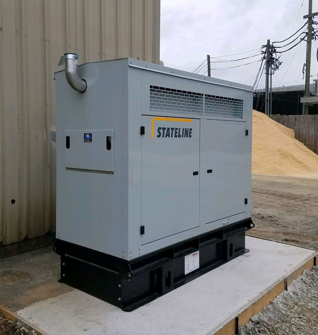 A Stateline generator is sitting outside of a building.