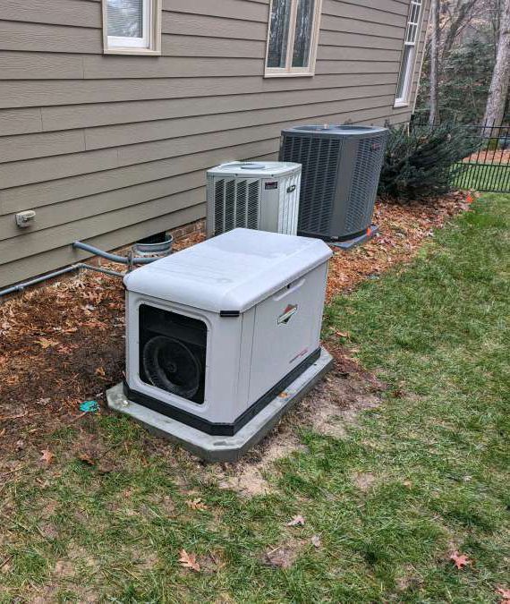 A generator is sitting in the grass next to a house.