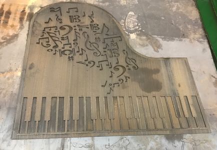 A wooden grand piano with a pattern of music notes on it.