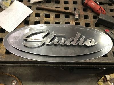 A metal sign that says studio is sitting on a table.