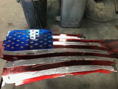 A red , white and blue american flag is sitting on a table.