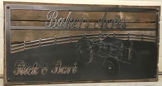 A metal sign with a tractor and a fence on it.