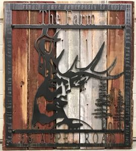 A wooden sign with a deer on it that says the farm