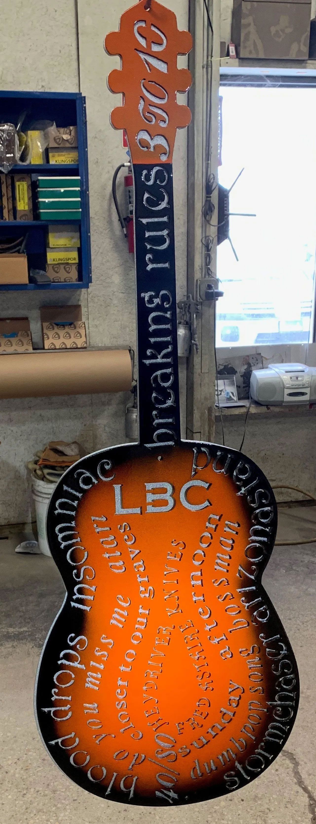 A guitar with a sign on it that says breaking rules