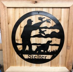 A wooden sign with a silhouette of a man and a dog and the name staller on it