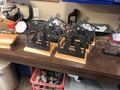 Three nativity scene candle holders are sitting on a table.