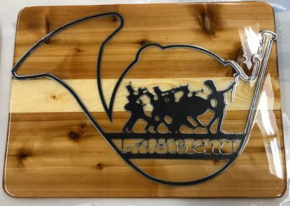 A wooden cutting board with a silhouette of a horn on it.