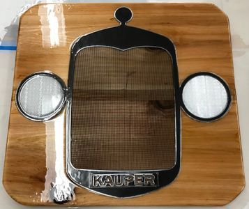 A wooden cutting board with a kauffer logo on it