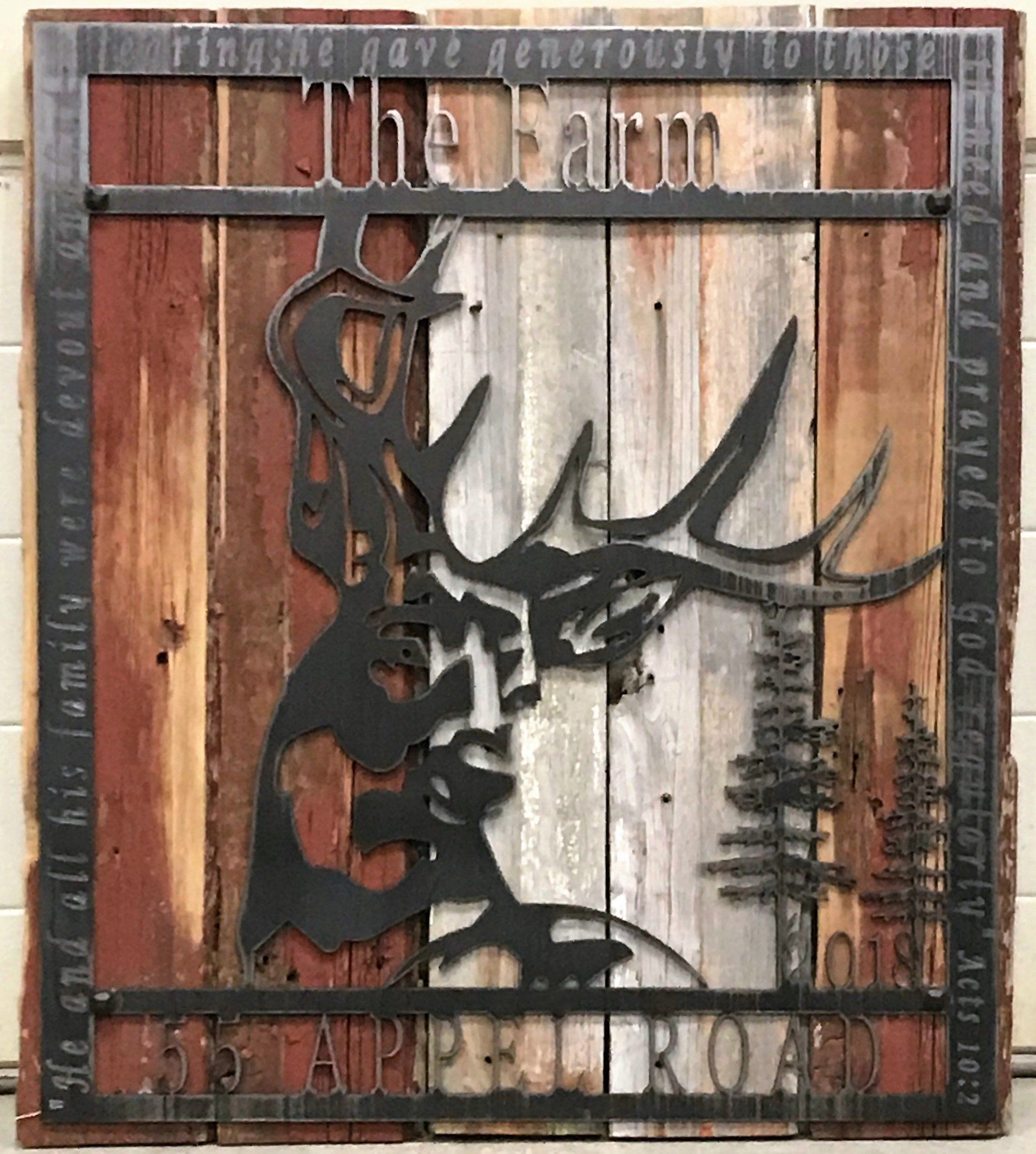 A wooden sign with a deer on it that says the farm