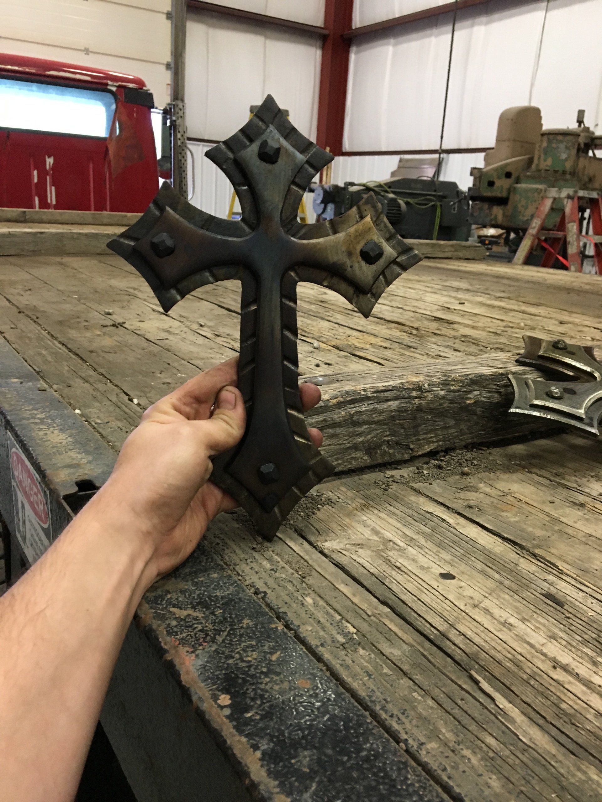 A person is holding a cross on a wooden table