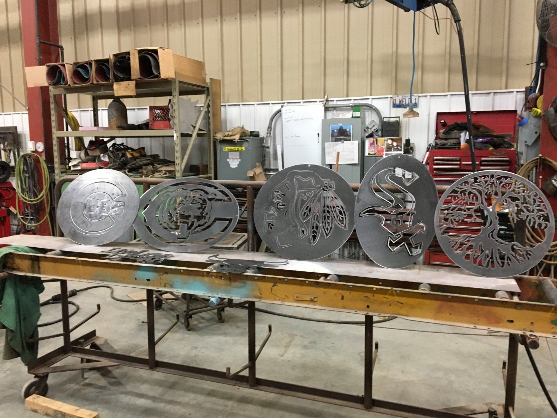 A bunch of metal pieces are sitting on top of a table in a factory.