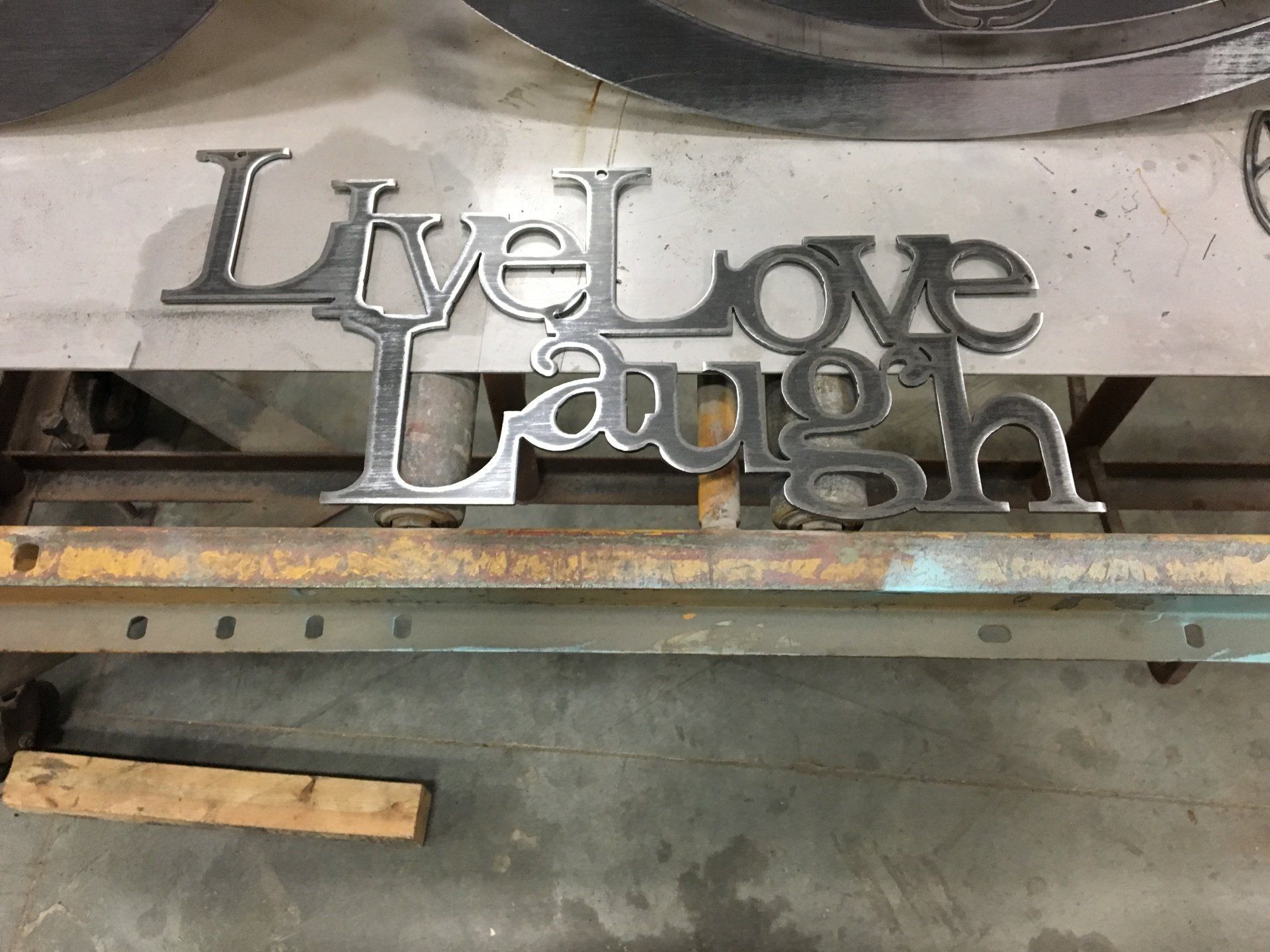 A metal sign that says live love laugh on it