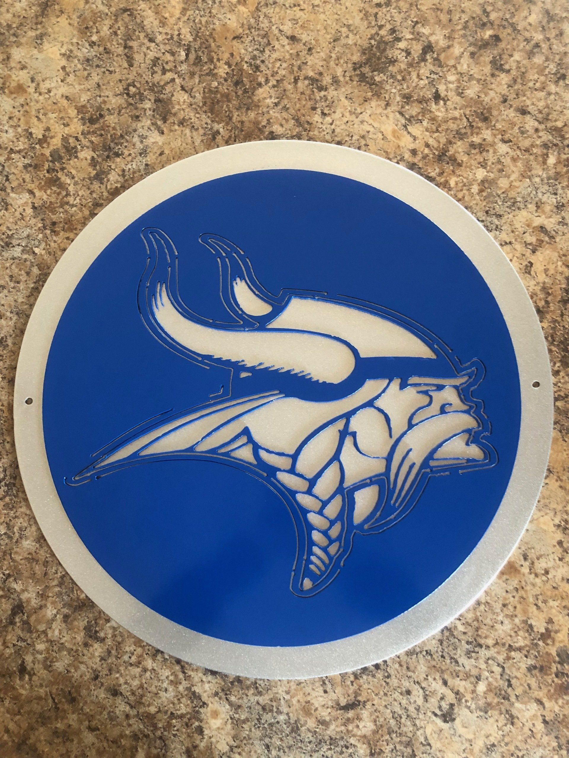 A blue and white circle with a vikings logo on it