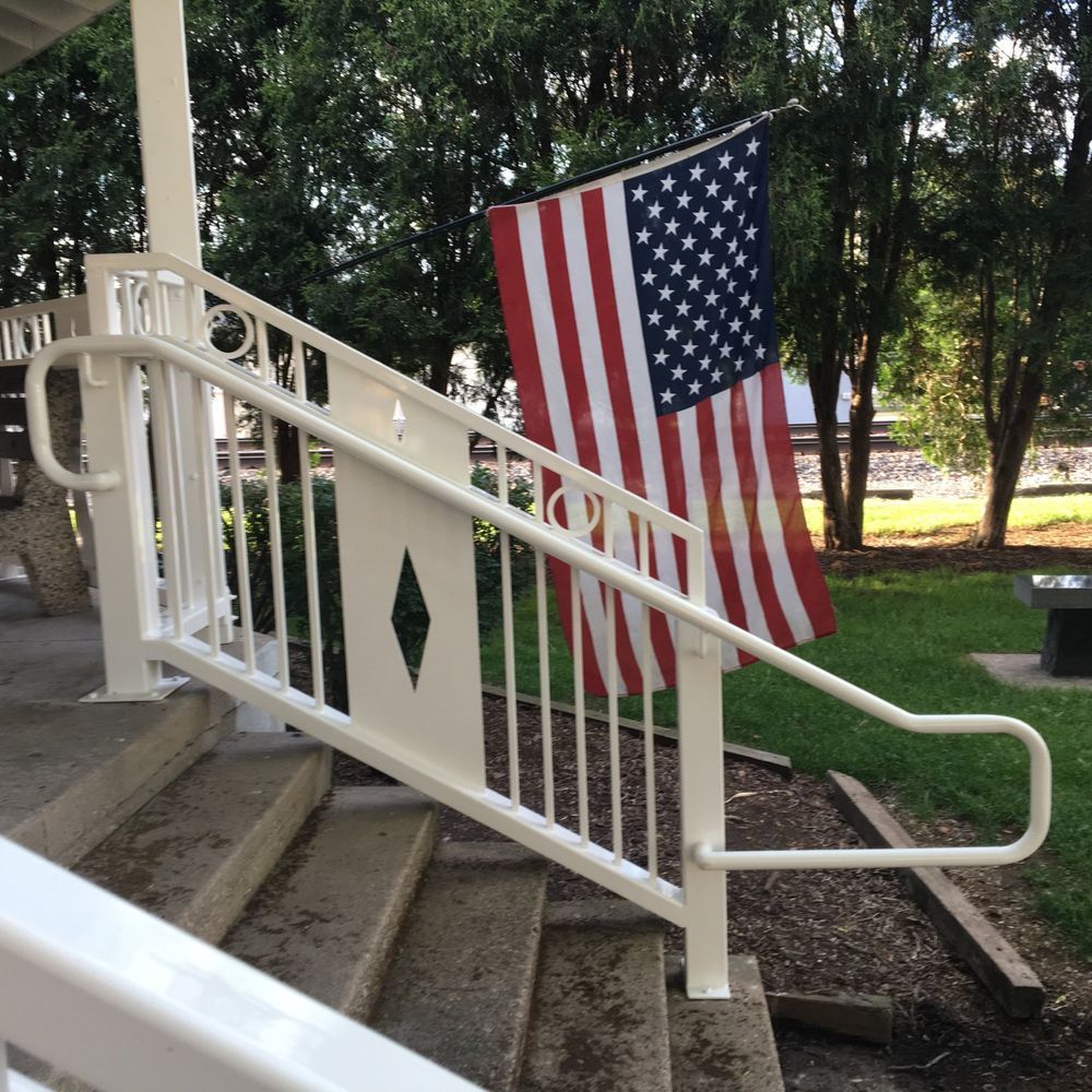 A white railing with an american flag hanging from it