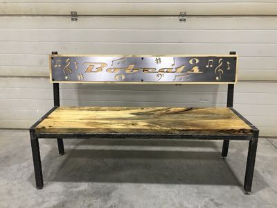 A wooden bench with a metal frame is sitting in front of a garage door.