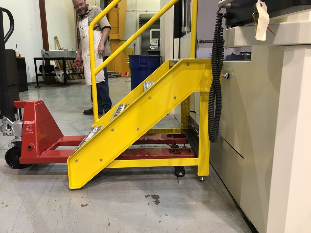 A red pallet truck with yellow stairs attached to it