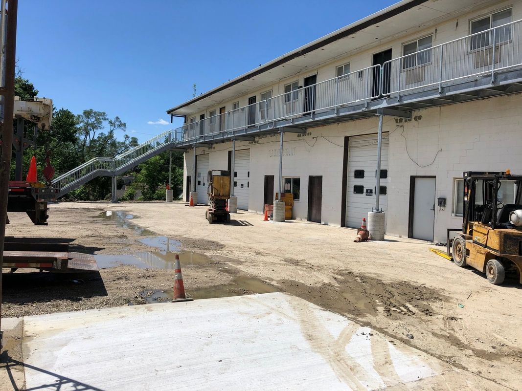 A forklift is parked in front of a building under construction.