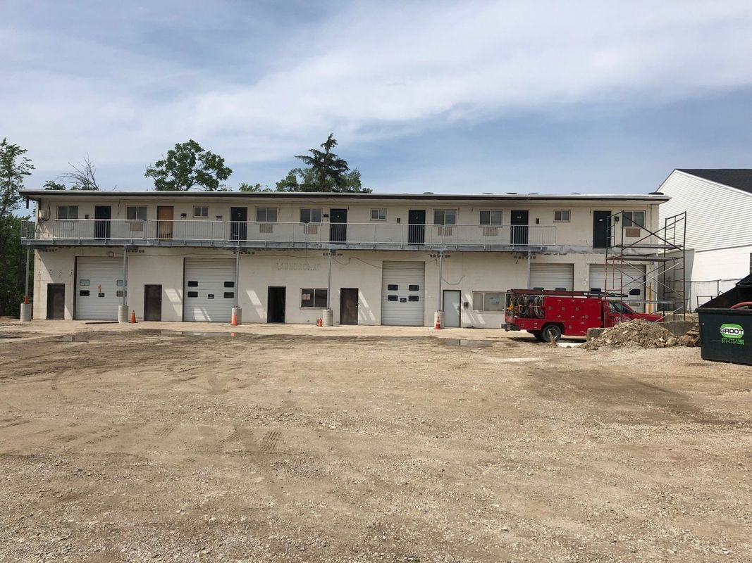 A red truck is parked in front of a building.