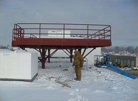 A man is standing on top of a snow covered platform.