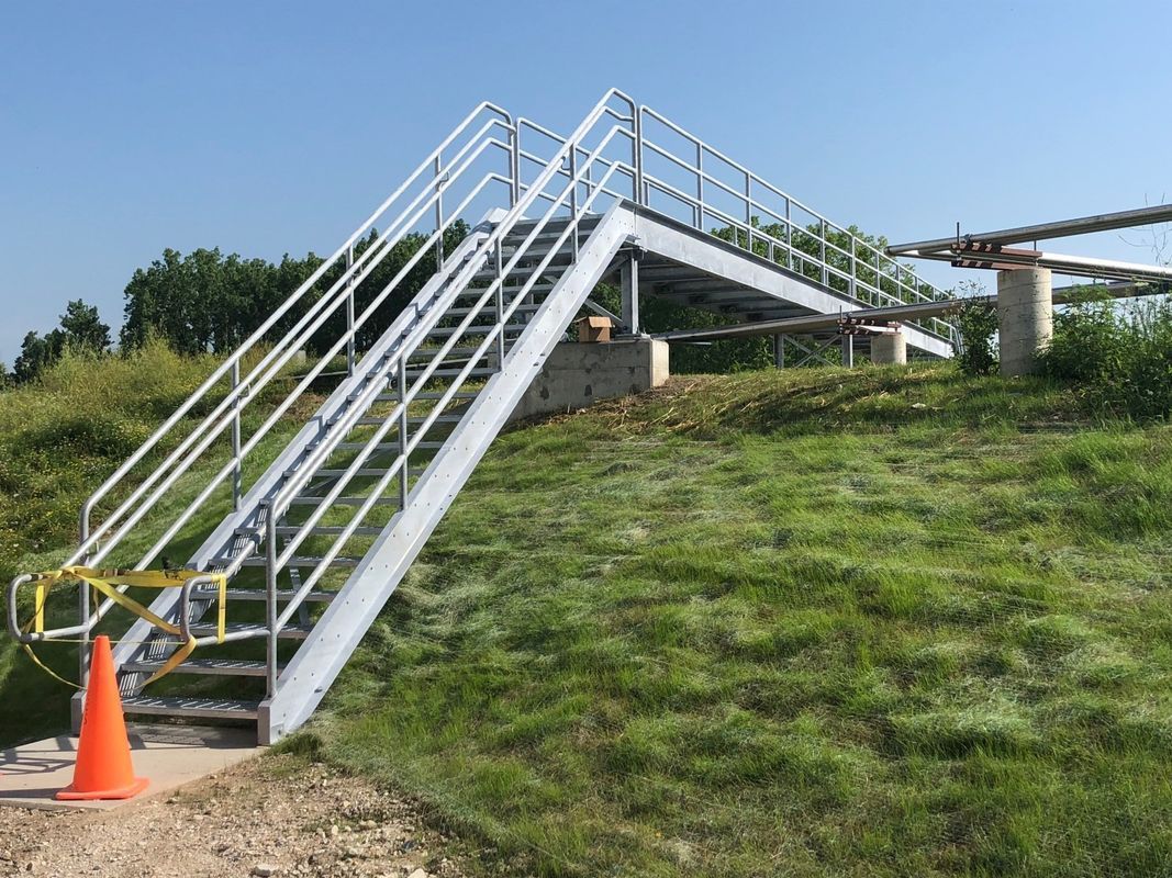 A set of stairs leading up to a grassy hill.