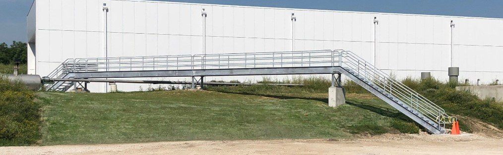 A white building with stairs leading up to it.