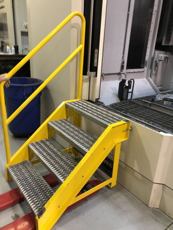 A yellow metal staircase with a yellow railing