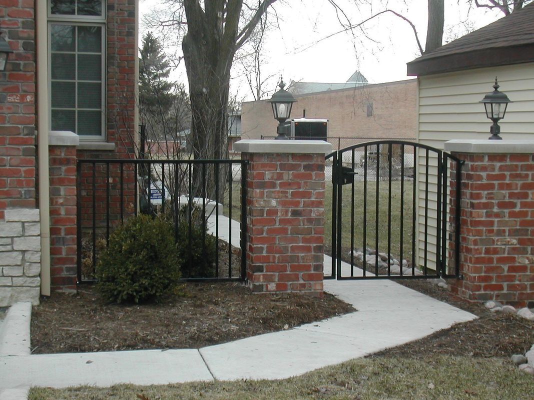 A brick wall with a metal gate in front of it