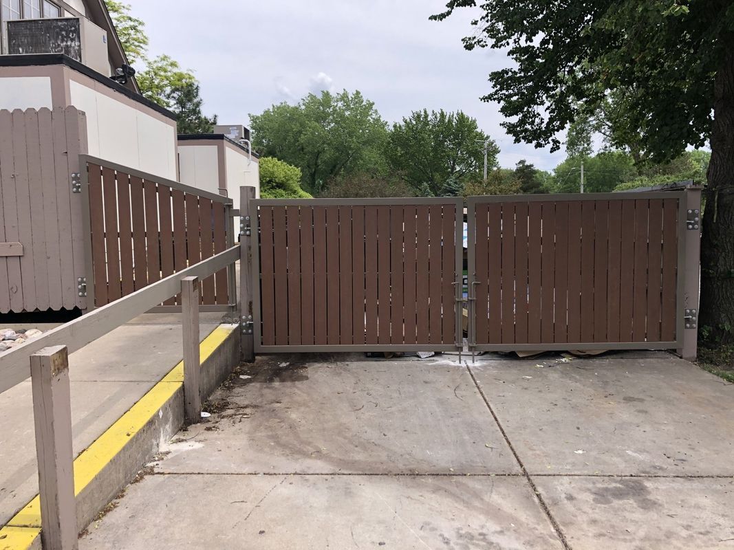 A wooden gate with a yellow stripe on the side of it