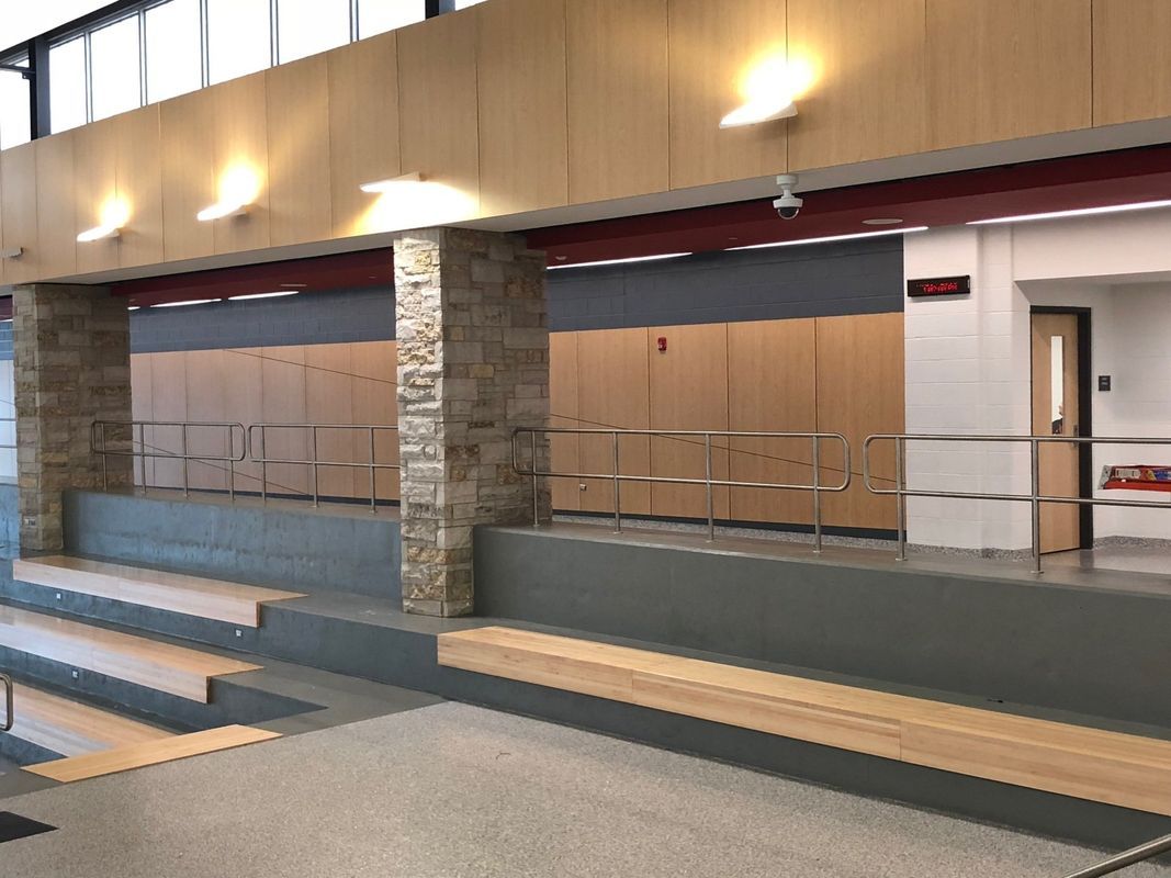 A hallway with stairs and a railing in a building